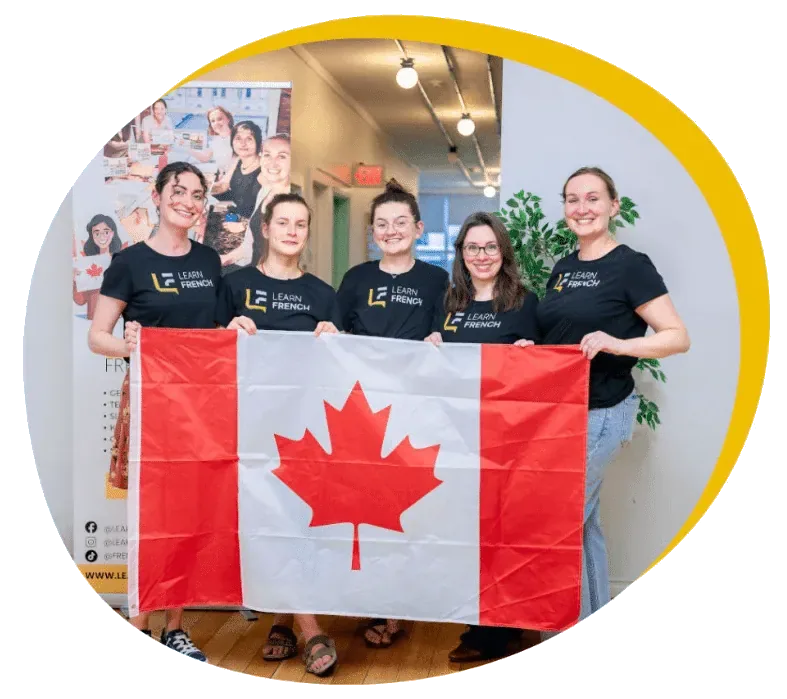 The Learn French Canada teaching team holding a Canadian flag