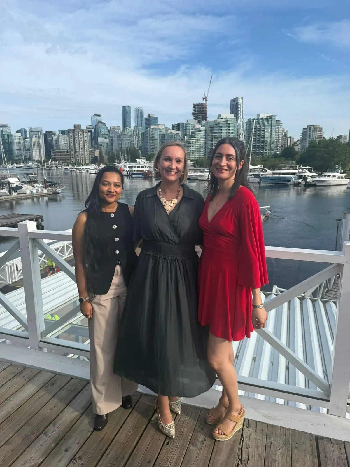 Learn French Canada team — Léa Granado, Aurélie Halimi, and Tasnia Anika — posing at Vancouver waterfront before the Palme Bleue Gala 2026